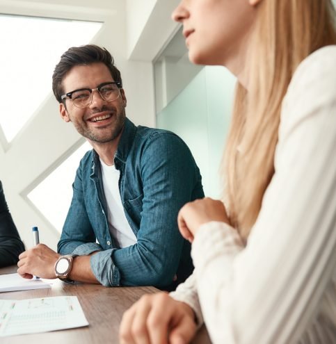 Morning meeting. Business team discussing something and smiling while sitting in the modern office. Brainstorming. Team work